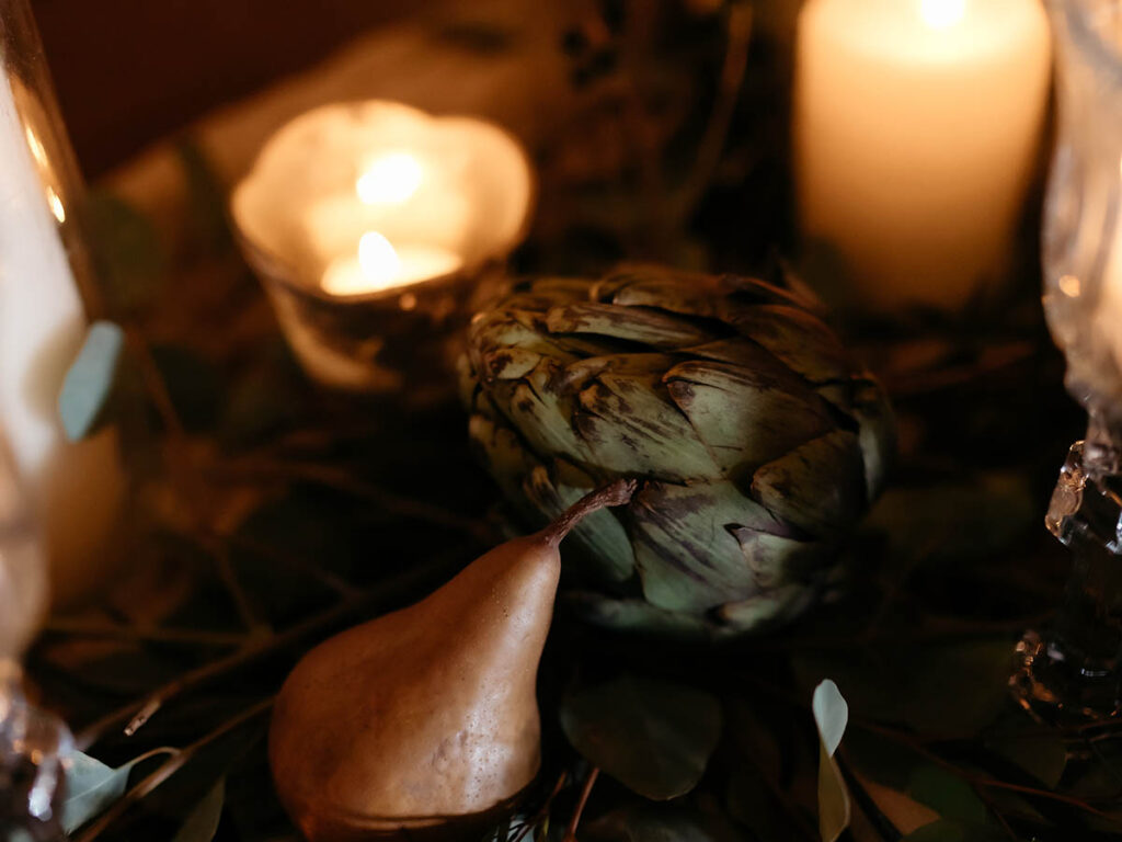 pear, artichoke and candle decorating table.